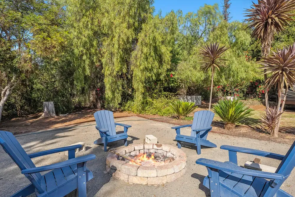Fire pit with Adirondack chairs in the garden of a Wings supportive housing home