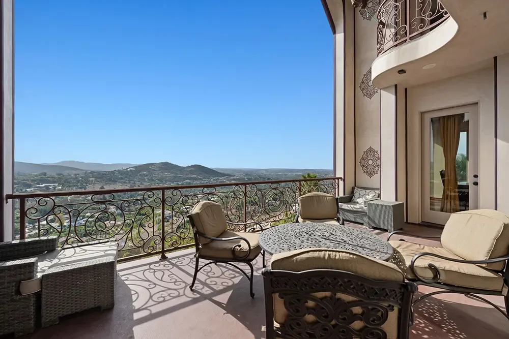 Covered terrace with outdoor seating and a view over the hills at a Wings home