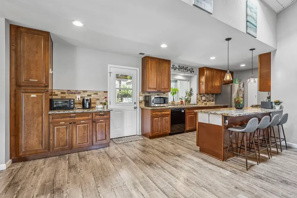 Kitchen with an island and bar stools in a Wings residential home